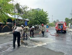 Antisipasi Laka, Polisi bersama Damkar Bersihkan Tumpahan Solar di Jalan Raya Lamongan