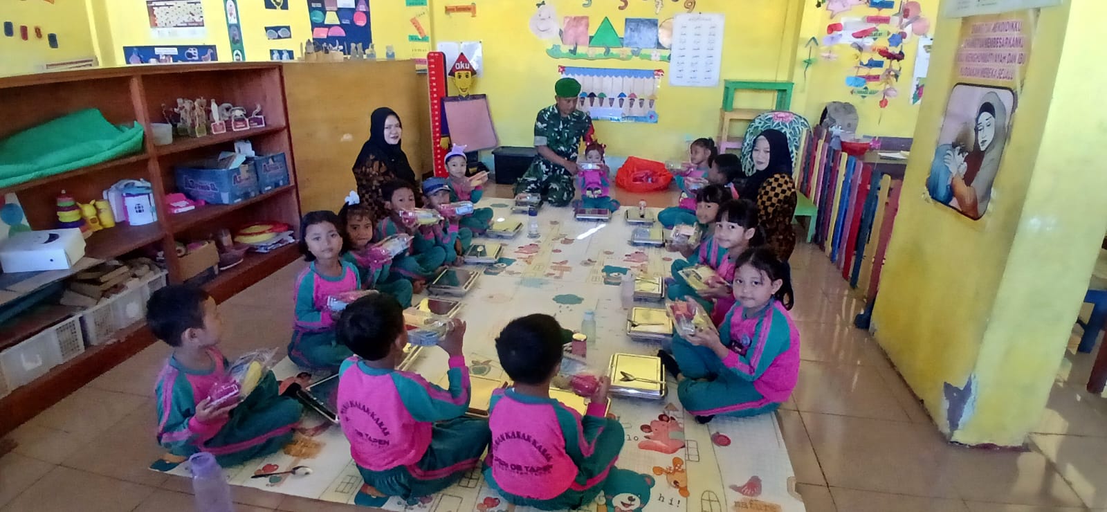 Ciptakan Suasana Ceria, Babinsa Tapen Duduk Bersama Murid TK PGRI 8 Saat Bagikan MBG